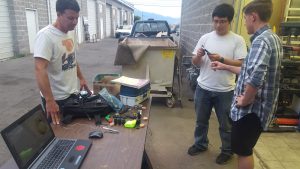 Ales (center) and 2 BYU students (left and right) work on a robot hand